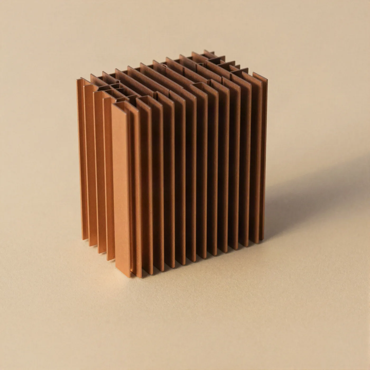 A heatsink photographed on tan paper in raking light — repeated fins cut from one block.